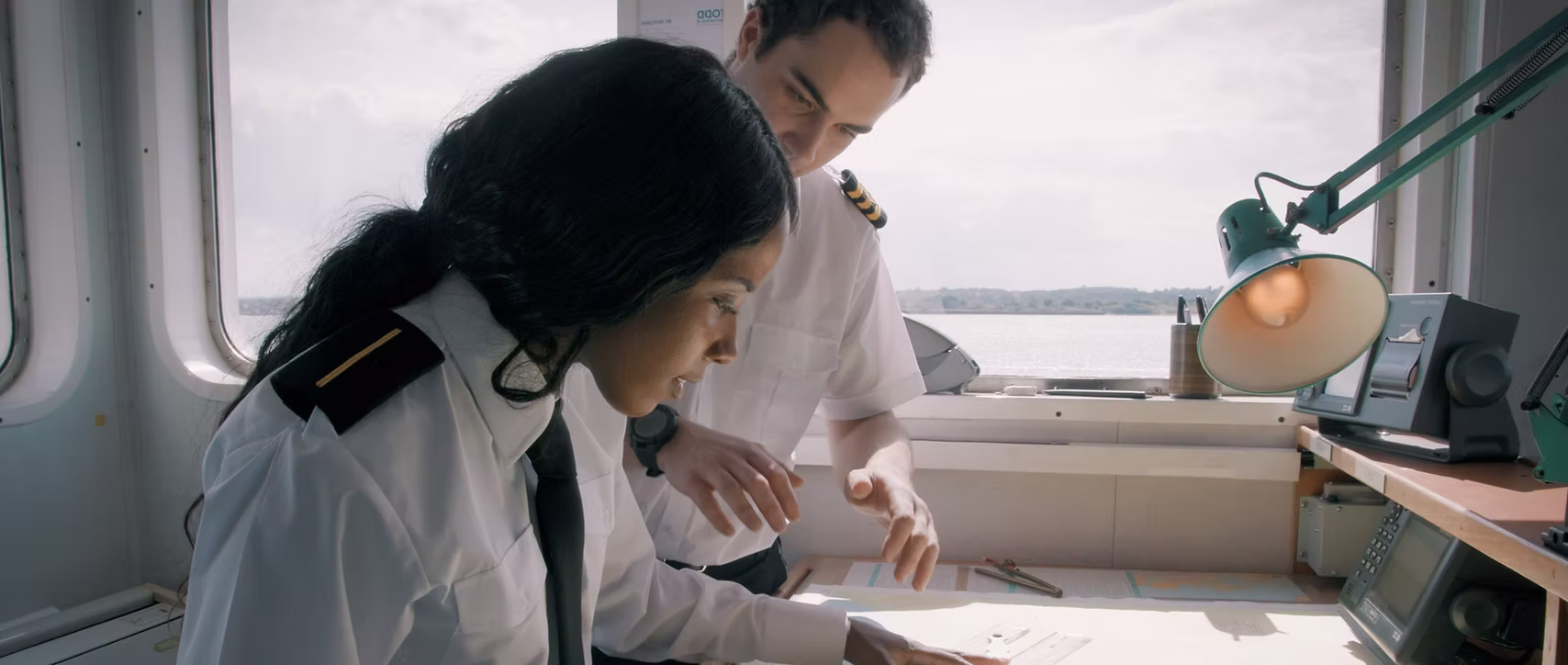 Captain and crew reviewing navigation map – cadet application process– bridge resource management review